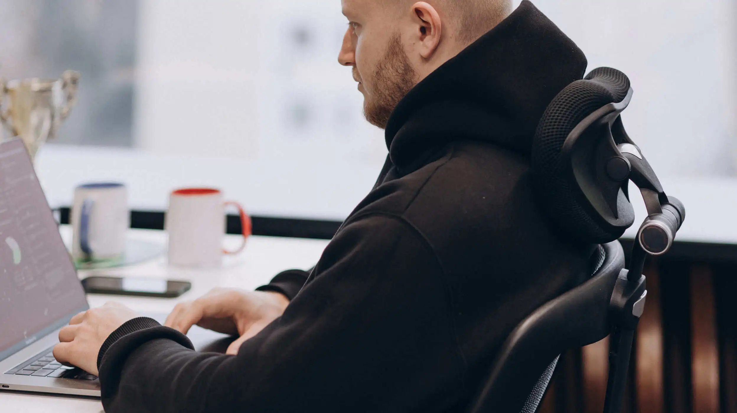 man in black sweatshirt in front of laptop