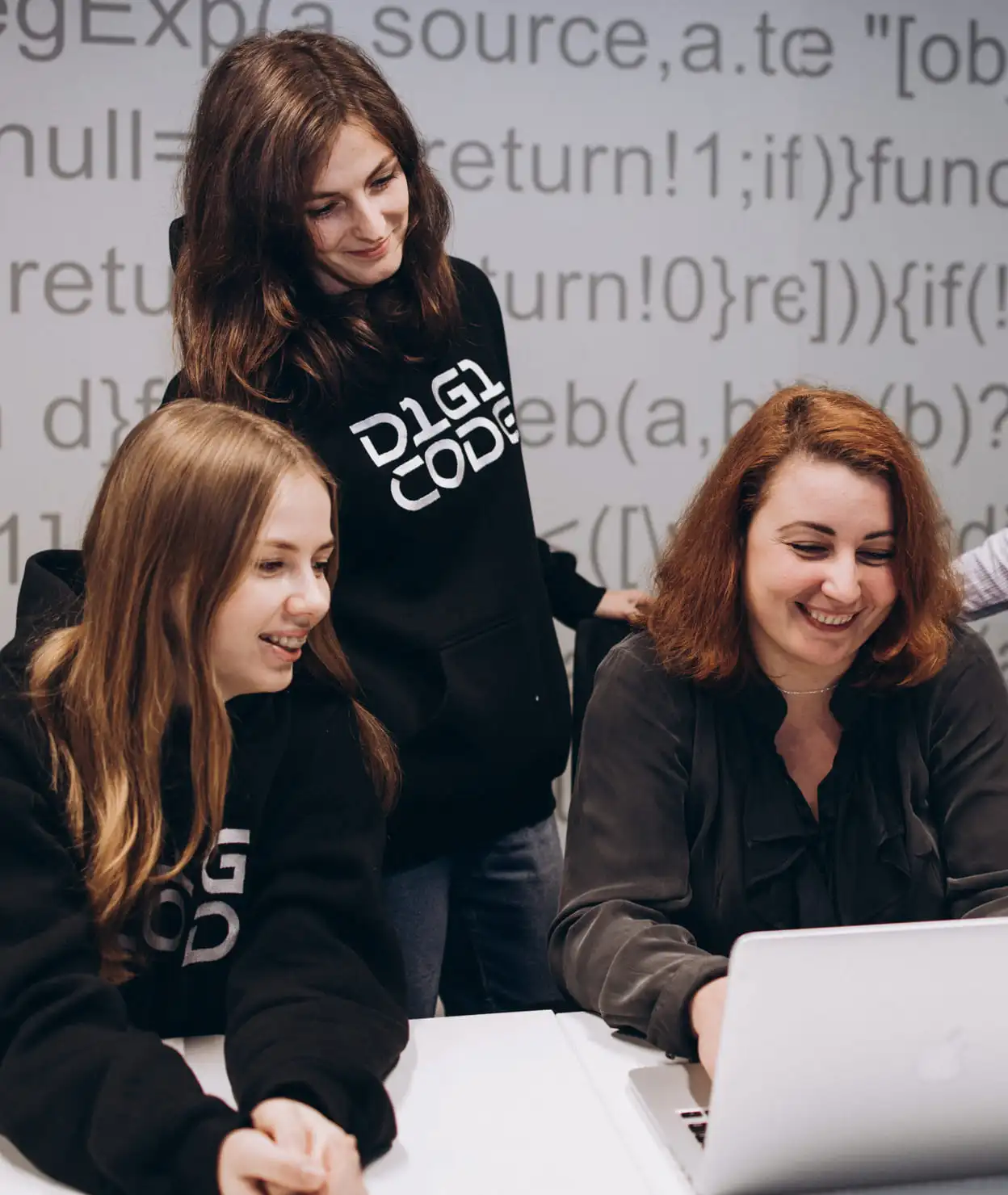 three smiling girls in front of laptop